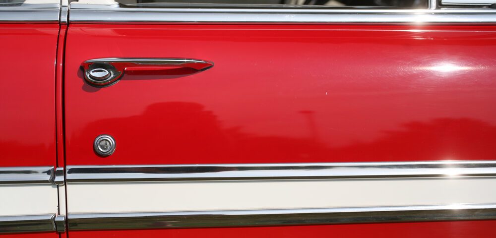 Red vintage car door with chrome handle.
