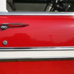 Red vintage car door with chrome handle.