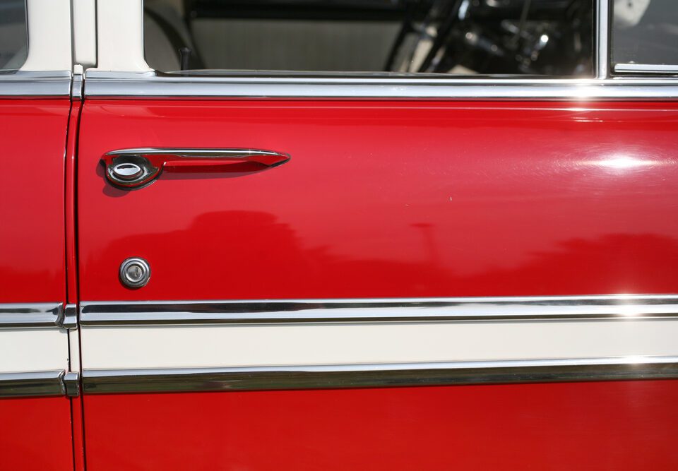 Red vintage car door with chrome handle.