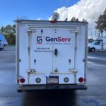 Rear view of a white GenServ utility truck with company branding and contact information.