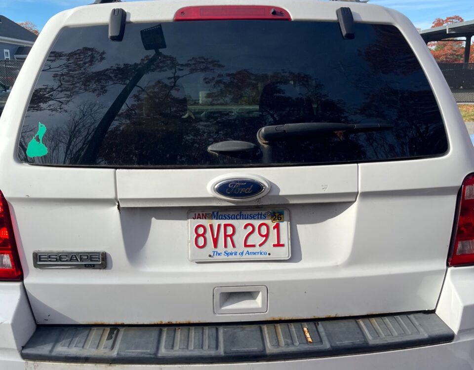 Rear view of a white SUV with a Massachusetts license plate.