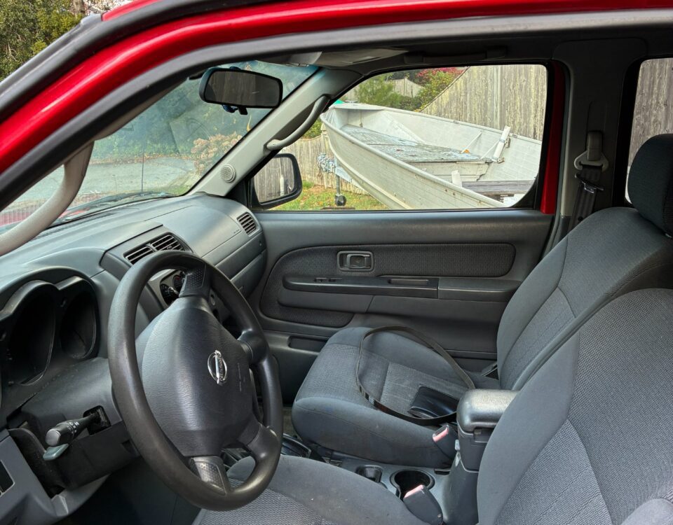 Interior of a red car showing the driver's seat and dashboard.