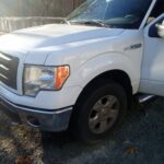 White pickup truck parked on gravel with visible front side.